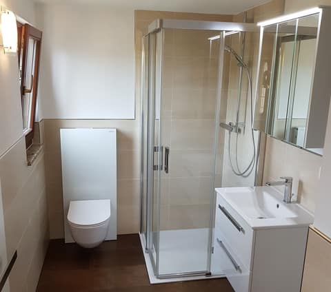 Neues Bad mit Eckdusche, Waschtisch und beleuchtetem Spiegelschrank